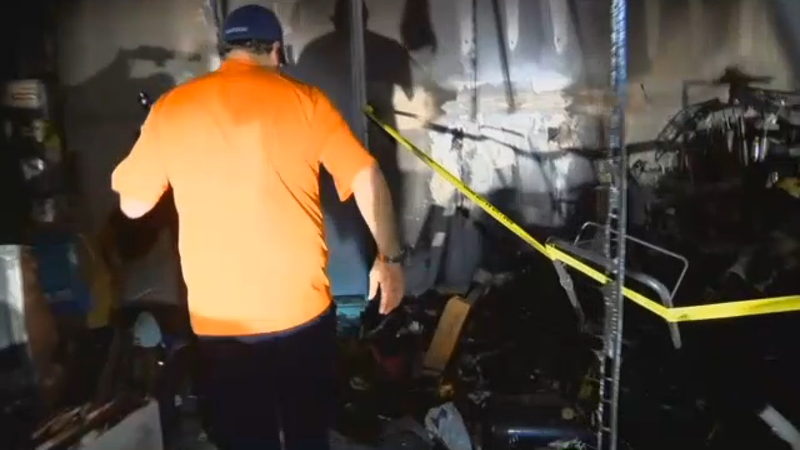 Wesley Hartzog walking through his burned out garage where it’s believed his Galaxy Note 7 started a fire (WMBF News screenshot)